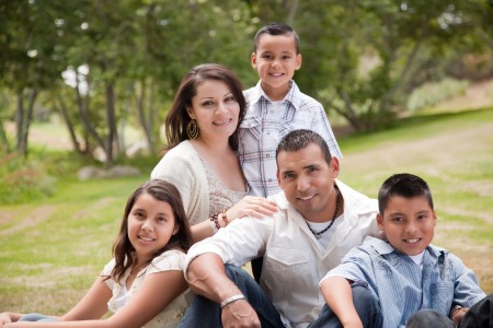 Happy Hispanic Family In The Park